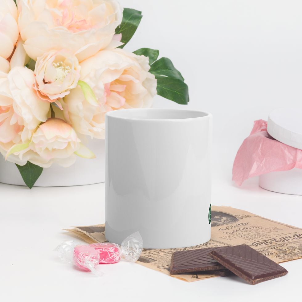 Thumbnail: White mug beside flowers, candy, and chocolate on a white background.