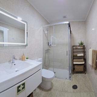 Banheiro moderno do Apartamento 2 com pia branca e box.
