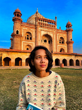 Shruti sitting with a book in hand at Safdarjung Tomb