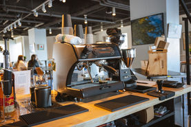 Professional espresso machine on a wooden coffee bar counter.