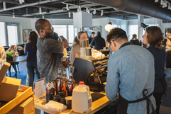 Two baristas preparing coffee drinks at a busy cafe counter.