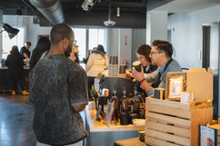 Man ordering coffee from baristas at a busy cafe counter.