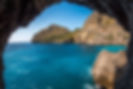 beautiful-shot-cliffs-near-ocean-through-natural-stone-arch.jpg