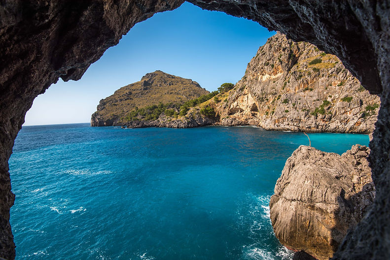 beautiful-shot-cliffs-near-ocean-through-natural-stone-arch.jpg