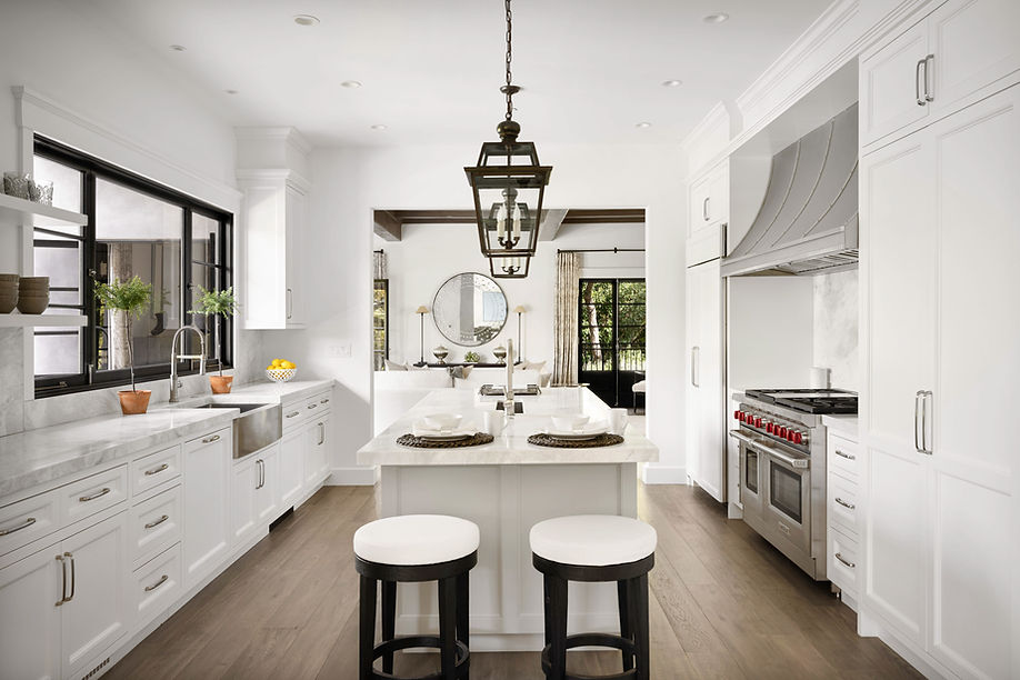 A modern kitchen featuring white cabinets and marble countertops, accented with a sleek bl