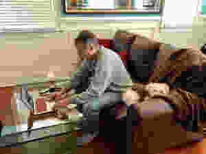 Man working at home on laptop with dog