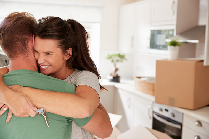 Couple hugging with key to house in hand