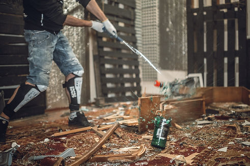 une personne cassant de la vaisselle dans une salle de destruction ou rage room ou fury room