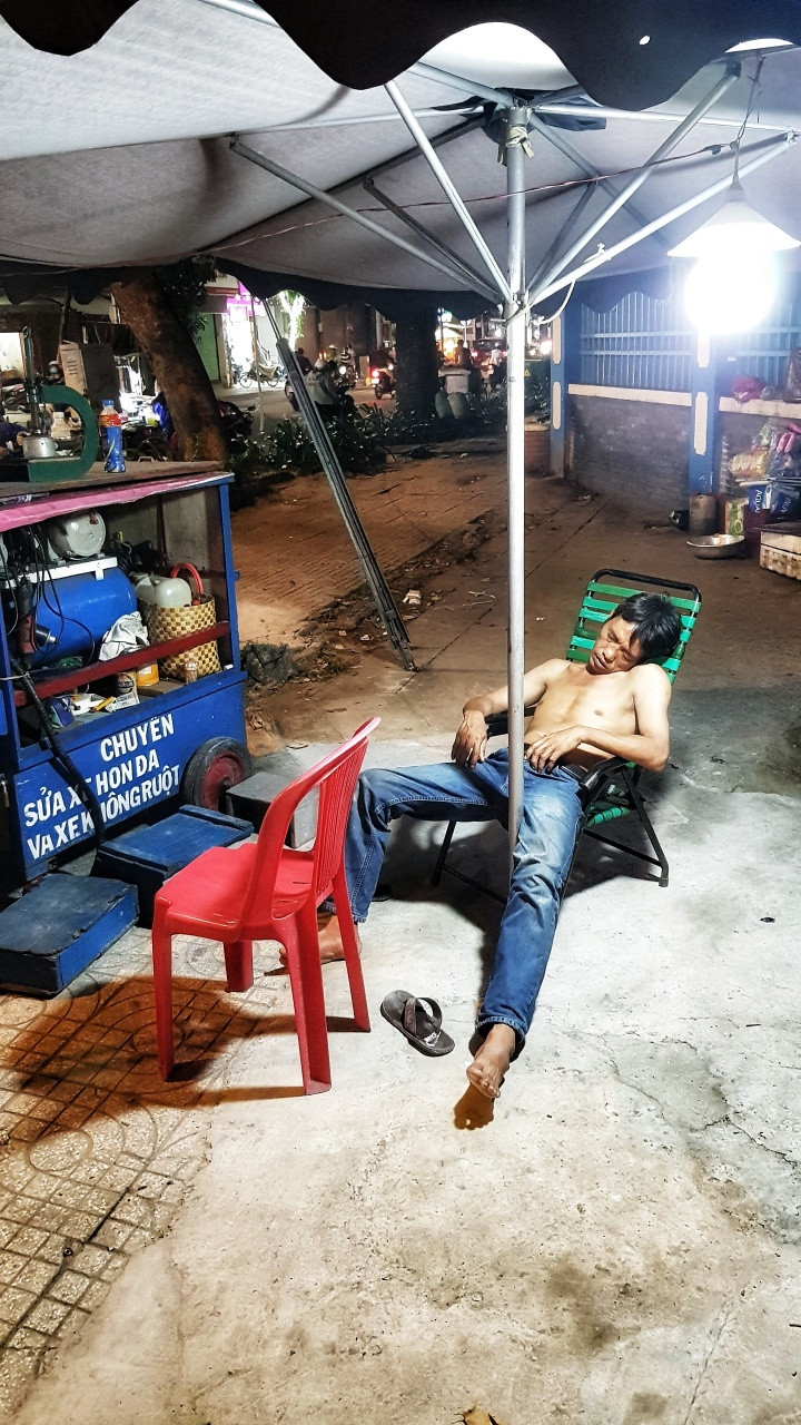 A mechanic sleeping on the side walk in Ho Chi Minh City, Vietnam