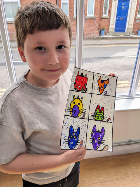 Boy showing finished artwork from an Arthouse kids and teens art class in Long Buckby