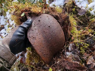 pulling a german helmet out from under the moss
