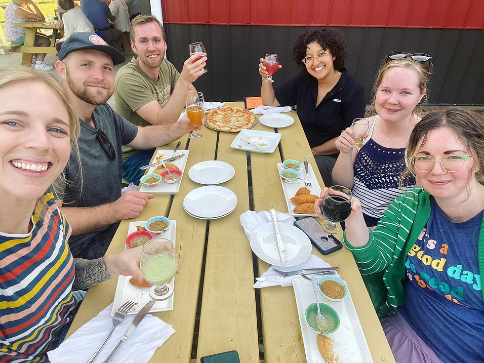 A group of people sitting at an outdoor table eating food at Harry Stuff Brewing Company in Wawaka Indiana