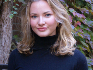 Headshot of author and hearing access advocate Caroline Itzkoff, with long blond hair and wearing a dark turtle neck