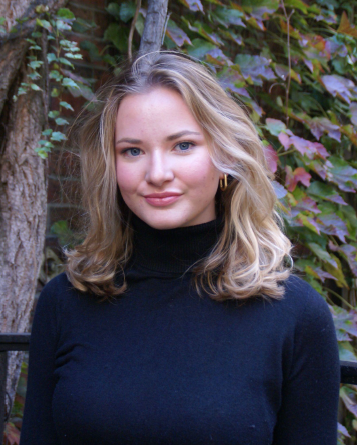 Headshot of author and hearing access advocate Caroline Itzkoff, with long blond hair and wearing a dark turtle neck 