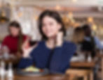 Woman smiling as she dines alone in a restaurant