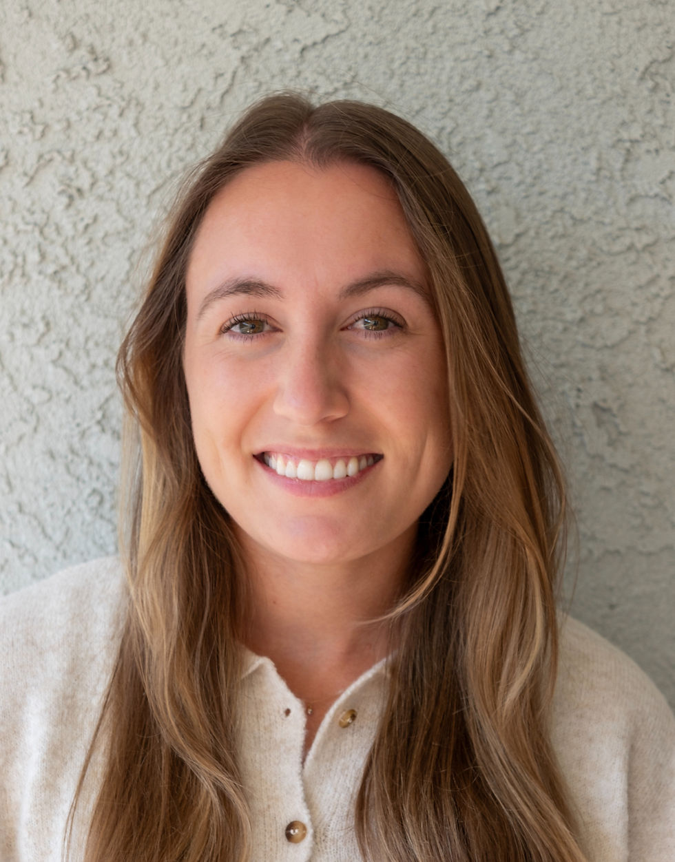 Headshot of Sophie Scott smiling and standing in front of a neutral background