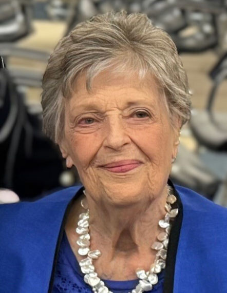 Headshot of Ruth Bernstein with gray hair, neckless and blue bright blue blazer