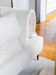 Divano bianco con cuscino, legno e tappeto. LK Arredamenti.