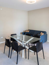 Modern dining table with chairs and blue sofa, LK Arredamenti.