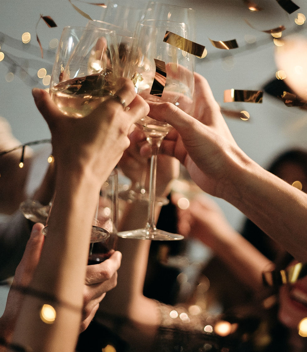 Wine glasses clinking with gold confetti falling in celebrantion