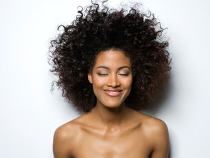 portrait of a woman with curly hair achieving facial balancing with filler