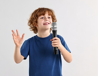 Little boy with microphone on light grey background, space for text.jpg
