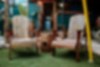 Wooden patio chairs on artificial grass in a cozy outdoor setting