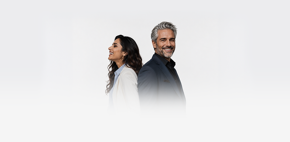An indian woman wearing work clothes and laughing with her back to the back of a gray-hair man smiling and wearing a suit.