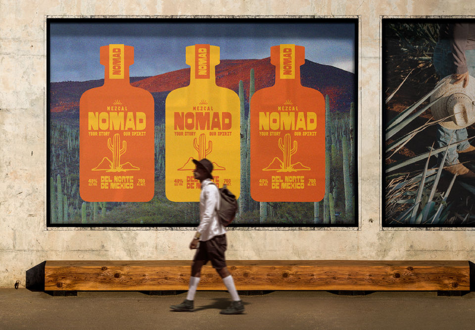 A person in a hat walks past a large wall mural on a street, featuring three bottles of NOMAD mezcal, prominently displaying the labels with bold text and colorful designs. The background includes desert scenery with cacti, emphasizing the product's Mexican heritage.
