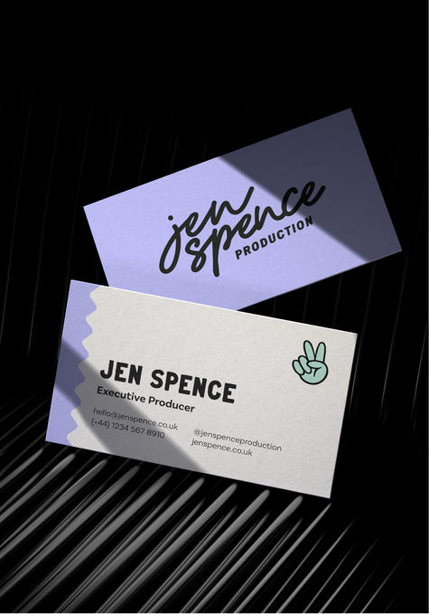 A business card showing both sides on a black grooved background. The front of the card is lilac and has a handwrtten logo in black cursive text that reads Jen Spence Producton. The back of the card is white with a lilac wiggle pattern down one side. The text on the card is black.