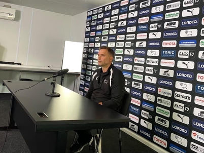 John Eustace sits at a desk for his pre-match press conference