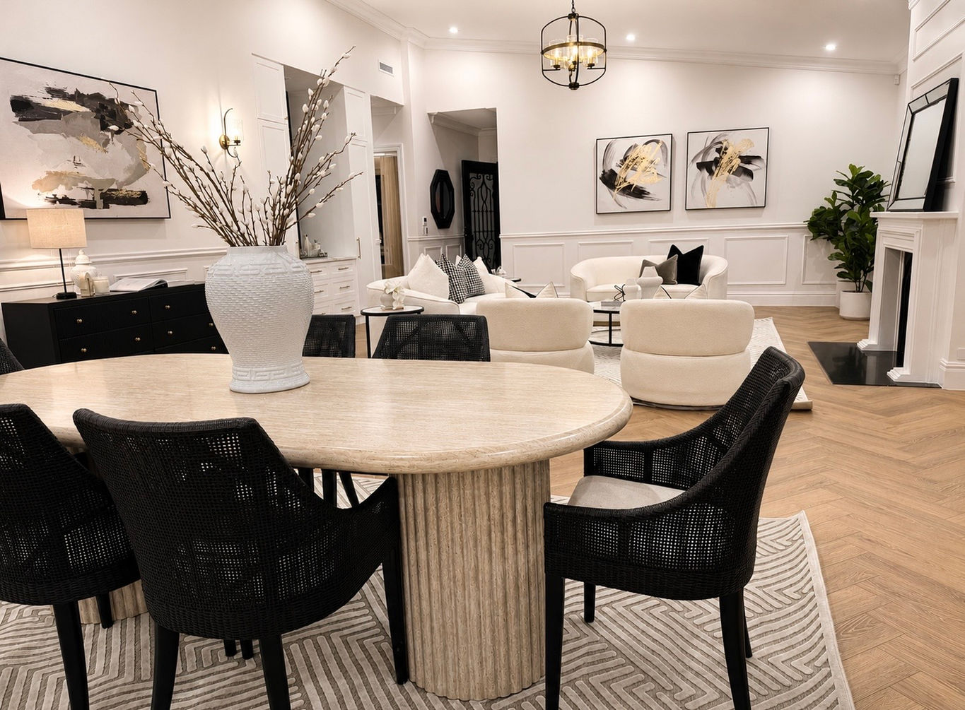 Designer dining room styling featuring a statement timber dining table, upholstered chairs, oversized mirror and curated decorative accessories.