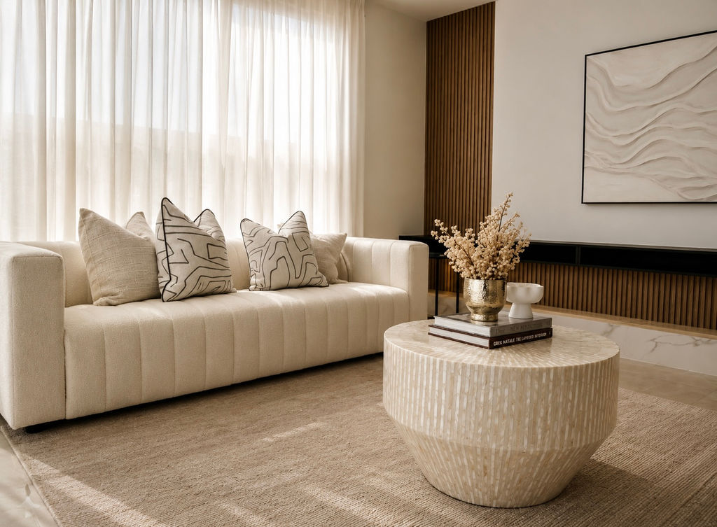 Contemporary living room in an Epping residence featuring sculptural bouclé seating, a statement coffee table and sophisticated neutral styling.