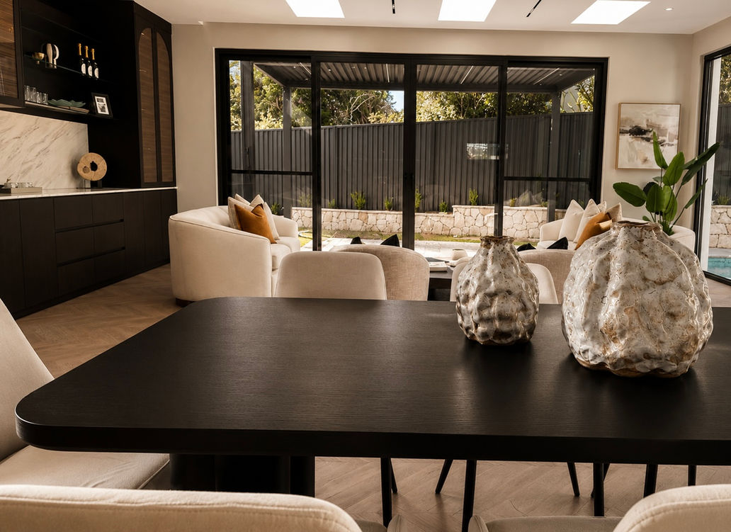 Modern dining area flowing into a sophisticated living space in an Epping residence, showcasing designer furniture, architectural joinery and refined neutral styling.