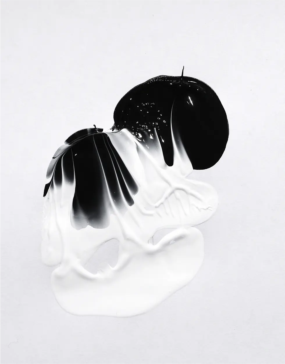 Abstract black and white acrylic paint flow resembling a melting shape on a light gray background.