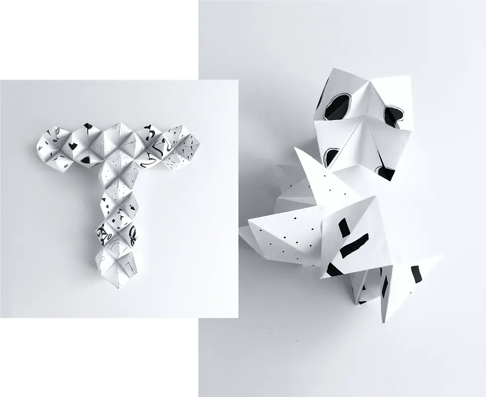 Handcrafted typographic paper sculptures from the ‘365 Days of Type’ project — folded white paper modules decorated with black ink marks and patterns.
