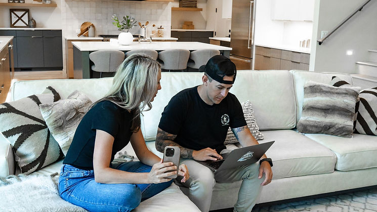 Man and woman, owners of Pod Shark Media, looking at a laptop, symbolizing how our boutique done-for-you digital media agency helps business owners save time through expert social media management, podcast production, and branded content creation.