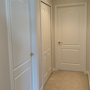 Narrow hallway with white doors. Interior Painting. Clean, bright Michigan interior painters.