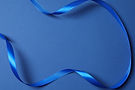 Beautiful blue silk ribbon on a color background.jpg