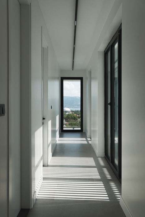 Bright modern corridor with floor-to-ceiling windows leading to the outdoor terrace at House 33 Sapanca.