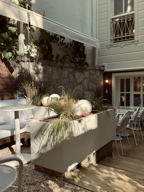 Kadıköy Moda House of SOFA kafenin avlusunda, şezlong ve mantar sehpa üzerinde latte kahve keyfi.