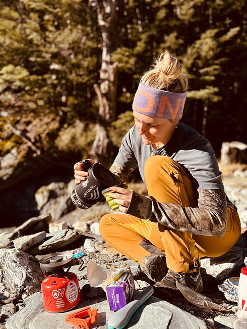 Megsy pouring a water from a cup during hiking session in new zealand