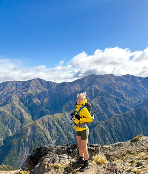 Megsy standing in a top of mountain during hiking session