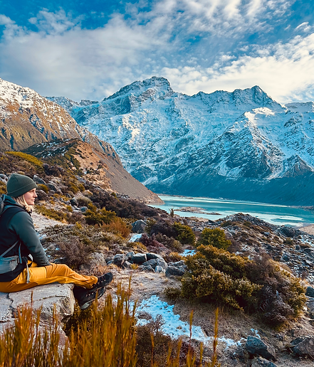 A women sitting on a rock in a mountain during a hiking session in New Zealand