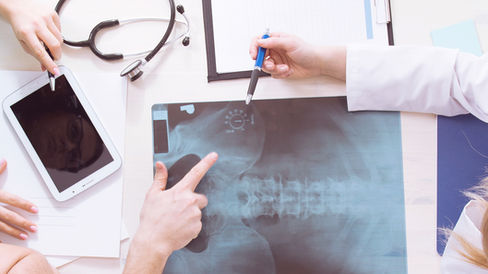 Above POV looking at a doctor and patient examining a back x-ray