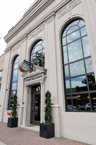 Exterior Strickland's entrance with arched windows and the text Strickland's Restaurant.
