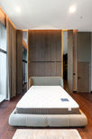 Minimal modern bedroom interior with custom cabinets and warm wood flooring