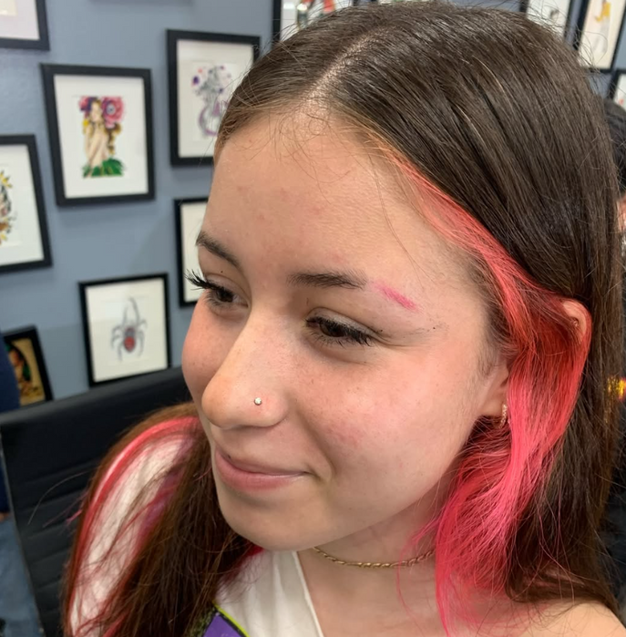 Child ear piercing performed by Kiyana at Darkstar Tattoo in Riverside, California.