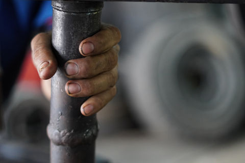 Close up of hand holding forklift tyre pressing machine