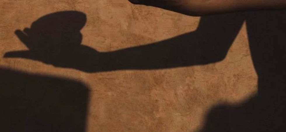Shadow of a cupped hand on a textured wall